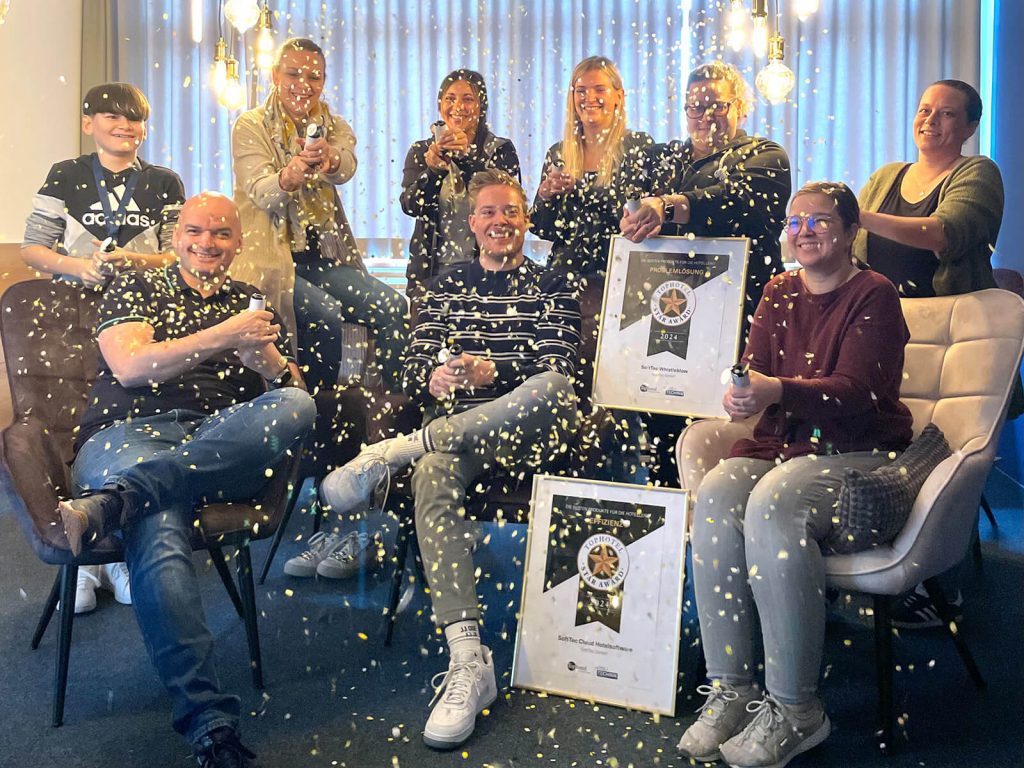 Das Team der SoftTec GmbH freut sich über zwei Tophotel Star Award Auszeichnungen und wirft Konfetti in die Höhe