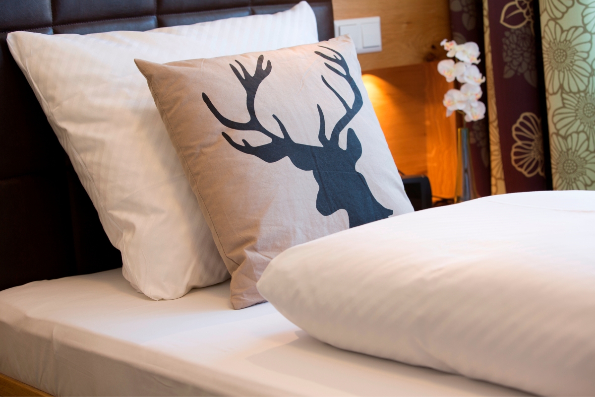 Frisch bezogenes Bett mit Hirschkissen im Hotel Rössle in Alpirsbach