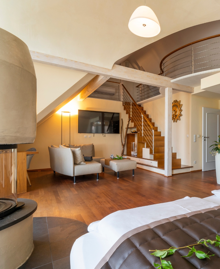 Maisonette-Zimmer mit Kaminofen, Galerie und Sitzbereich im Boutiquehotel Zur Winzerstube in Hagnau