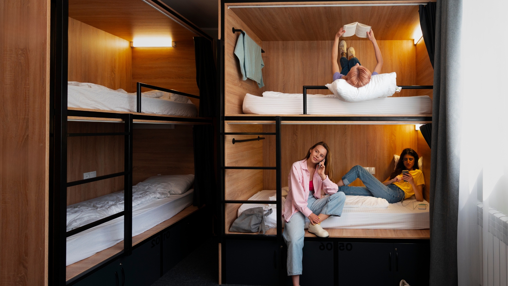 Junge Gäste in modernen Etagenbetten im Hostel-Mehrbettzimmer, verwaltet mit dem Hostel Management System von SoftTec