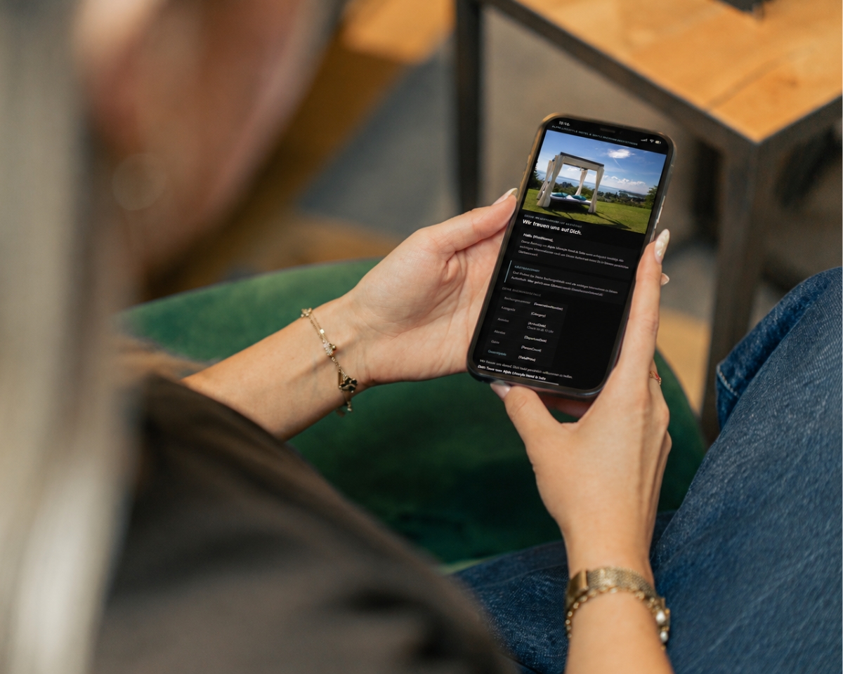 Gast liest eine individuell gestaltete HTML-Mail ihres Hotels im Dark Mode auf dem Smartphone