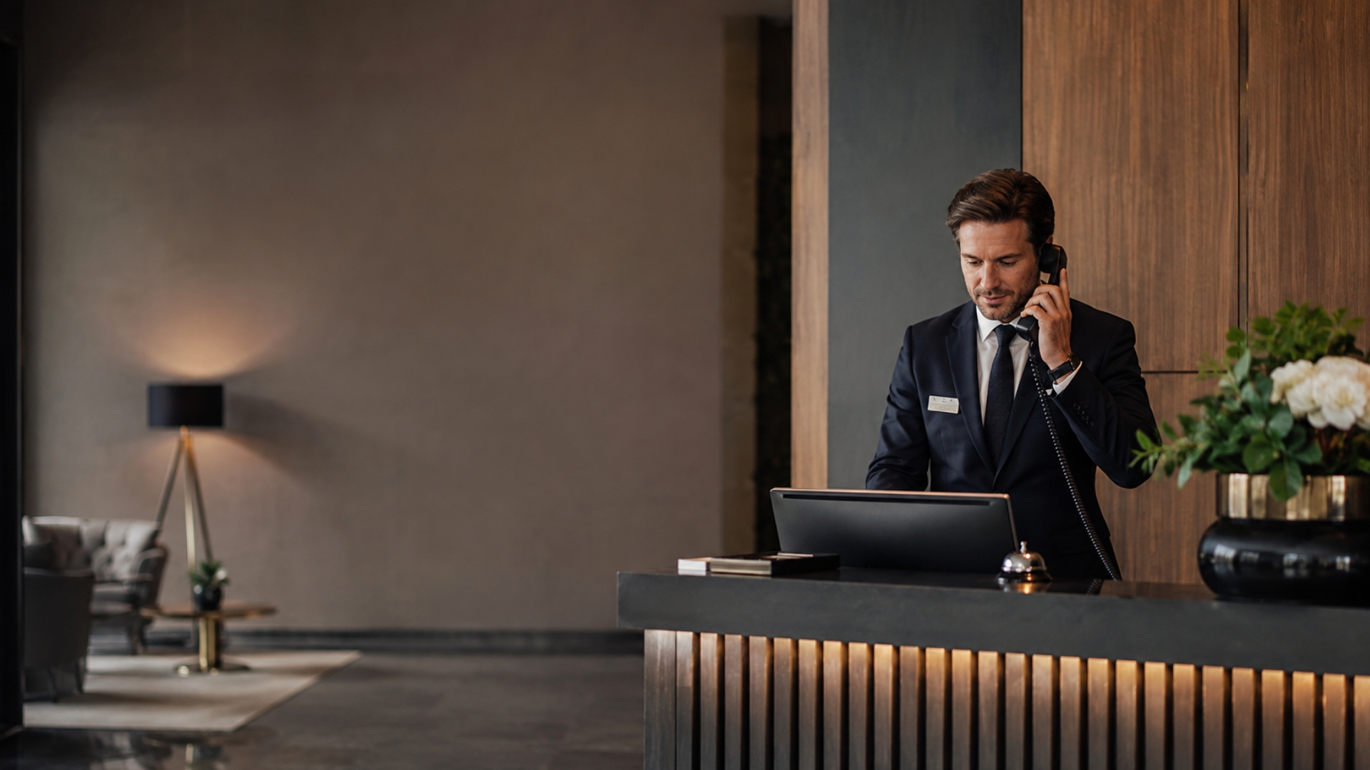 Hoteldirektor telefoniert am Empfang und arbeitet in der SoftTec Cloud Hotelsoftware