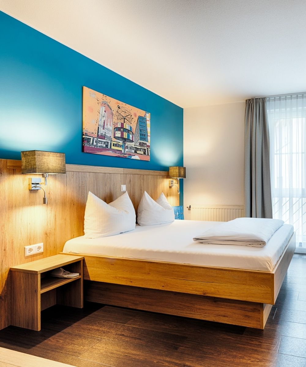 Doppelzimmer im Businesshotel Berlin mit Holzvertäfelung, türkiser Wand und Wandbild der Berliner Weltzeituhr
